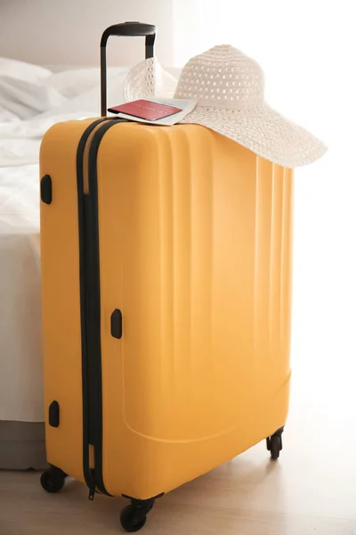 Большой чемодан, шляпа и документы в помещении — стоковое фото