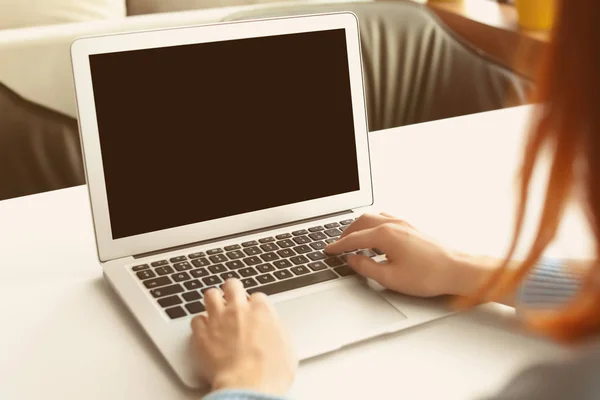 Young woman using laptop indoors Stock Photo