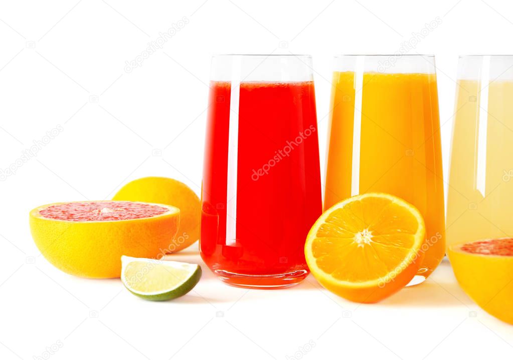 Different fresh juices in glasses and cut fruits on white background