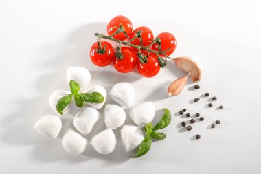 Mozzarella peynir topları, cherry domates, sarımsak ve beyaz arka plan üzerinde fesleğen