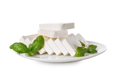 Dilimlenmiş işlenmiş peynir ve beyaz arka plan üzerinde fesleğen ile plaka