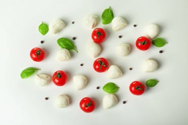 Mozzarella peynir topları, kiraz domates ve fesleğen beyaz arka plan üzerinde kompozisyonu