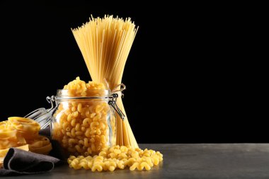 Koyu arka plan karşı masada farklı pişmemiş makarna