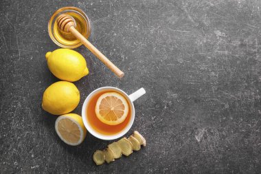 Bal, limon ve gri arka plan üzerinde zencefil ile lezzetli çay