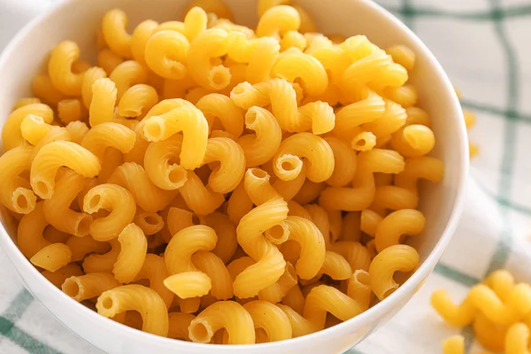 Bowl with uncooked pasta on table, closeup — Stock Photo, Image