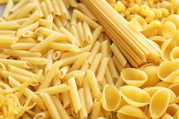 Different uncooked pasta as background, closeup — Stock Photo, Image