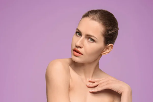 Krásná mladá žena s přirozeným make-up na barevném pozadí — Stock fotografie