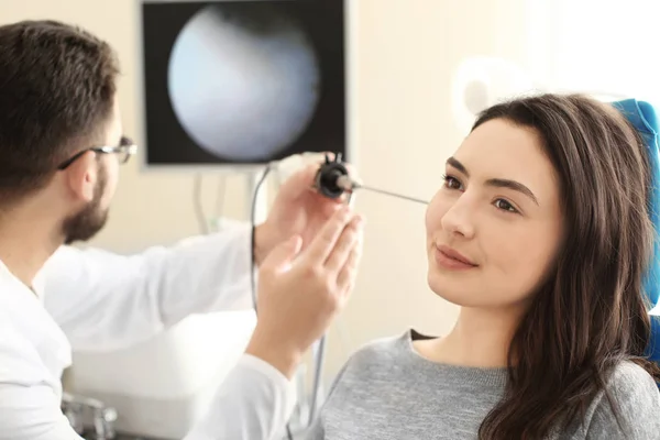 Otorinolaryngologů zkoumání ženské ucho s dalekohledem ORL v nemocnici — Stock fotografie