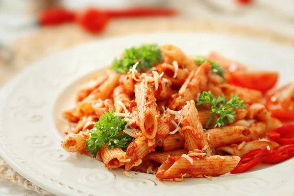 Tasty penne pasta with tomato sauce on plate, closeup — Stock Photo, Image