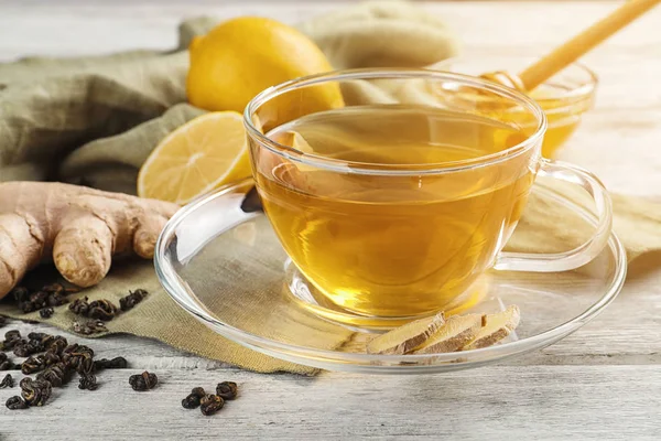 Cup of delicious tea with lemon and ginger on table — Stock Photo, Image