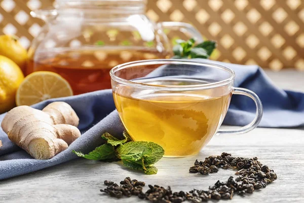 Cup of delicious tea with mint, ginger and lemon on table — Stock Photo, Image