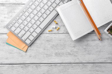 Bilgisayar klavye ve ileti örneği, düz ahşap arka plan üzerinde yatıyordu. Çalışma alanı tablosu kompozisyon