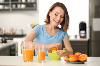 Güzel kadın mutfakta narenciye suyu sıkma