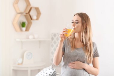 Güzel bir hamile kadın evde narenciye suyu içme