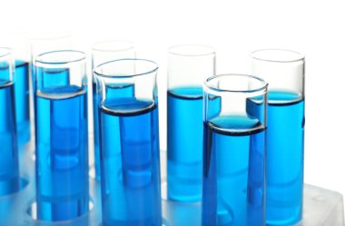 Beyaz zemin üzerinde mavi sıvı bulunan test tüpleri
