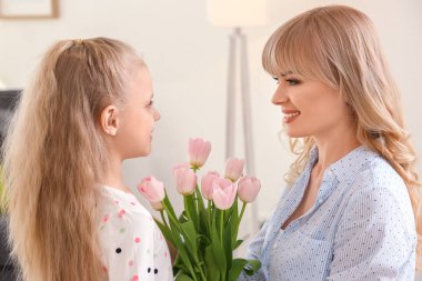 Sevimli küçük kız ve annesi Lale buketi evde ile portre