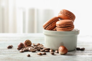 Karşı açık renkli ahşap masa üzerinde çikolata macarons ile kompozisyon