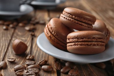 Ahşap masa üzerinde lezzetli çikolata macarons plakalı