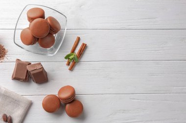 Ahşap arka plan üzerinde lezzetli çikolata macarons ile düz yatıyordu kompozisyon