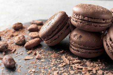 Lezzetli çikolata macarons ve kakao çekirdekleri, closeup ile kayrak plaka