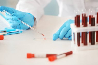 Kan örneği test tüp ile masada çalışan kadın