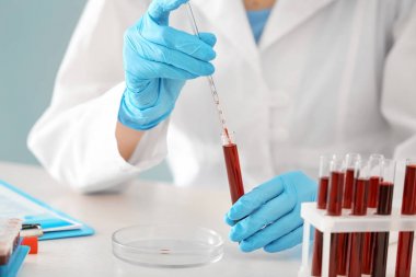 Tüp kan örneğinde ile masada çalışan kadın