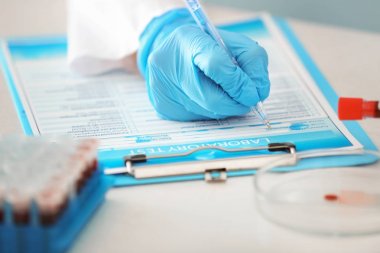 Kan örnekleri test tüpleri ile masada çalışan kadın