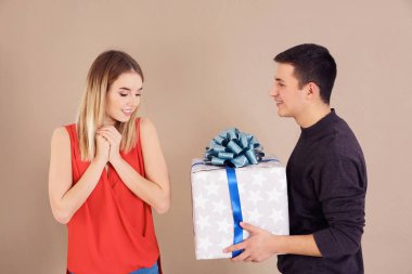 Renk arka plan üzerinde sevgili kız arkadaşına hediye veren genç adam