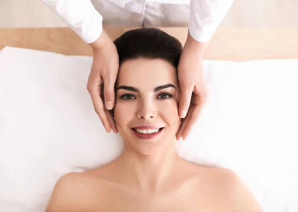 Mujer joven disfrutando de masajes faciales en el salón de spa —  Fotos de Stock