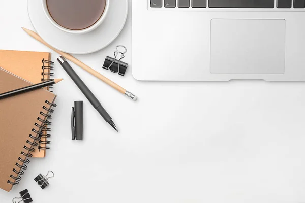 Laptop, cup of coffee and stationery on white background, flat lay. Workplace table composition — Stock Photo, Image