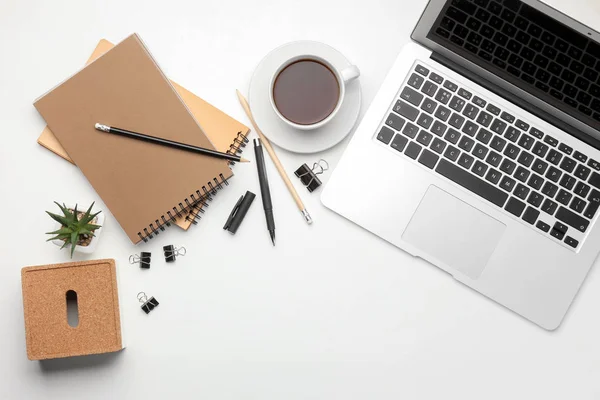 Portátil, taza de café y papelería sobre fondo blanco, plano. Composición de la mesa de trabajo — Foto de Stock