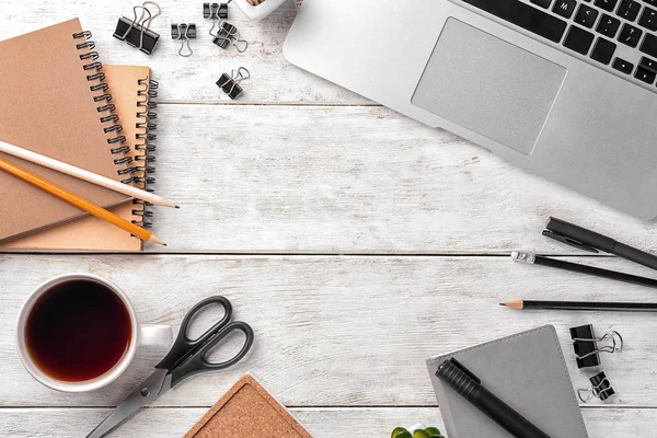 Laptop, cup of coffee and stationery on wooden background, flat lay. Workplace table composition — Stock Photo, Image