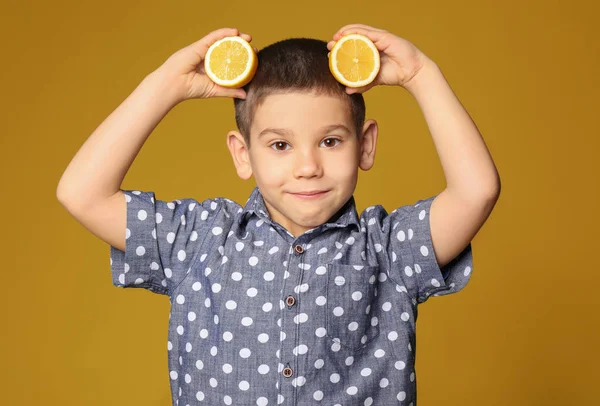 Engraçado menino com frutas cítricas no fundo de cor — Fotografia de Stock