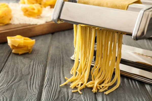 Metal pasta maker with dough on kitchen table — Stock Photo, Image