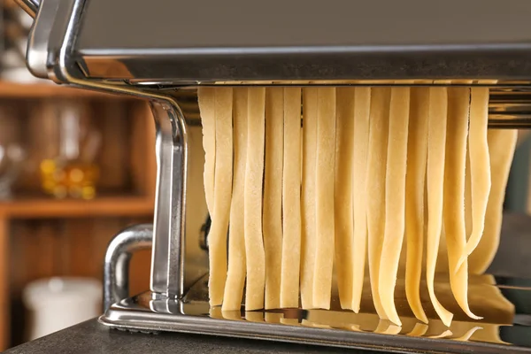 Metal pasta maker with dough on table — Stock Photo, Image