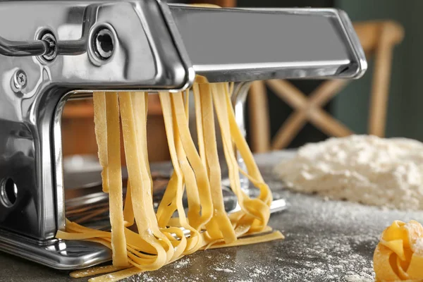 Metal pasta maker with dough on table, closeup — Stock Photo, Image