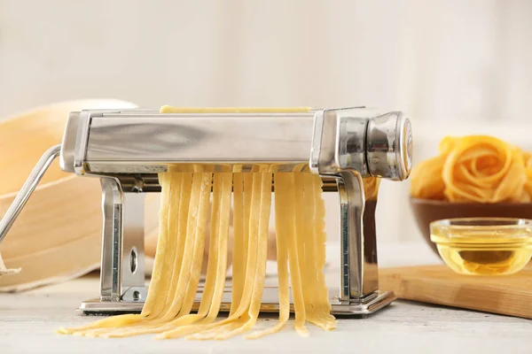 Macchina per pasta in metallo con pasta sul tavolo della cucina — Foto Stock