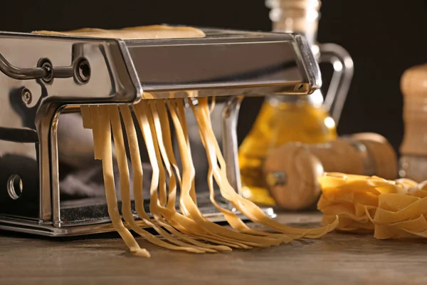 Nudelmaschine aus Metall mit Teig auf Küchentisch — Stockfoto