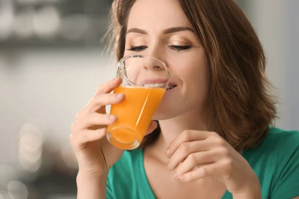 Mooie vrouw, drinken van SAP van citrusvruchten op onscherpe achtergrond — Stockfoto