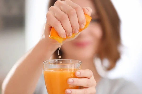 Jovem mulher espremendo suco cítrico, close-up — Fotografia de Stock