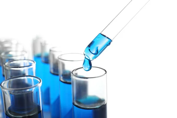 Despejar líquido azul em tubos de ensaio sobre fundo branco — Fotografia de Stock