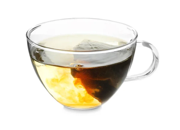 Заварювання гарячого чаю в скляній чашці на білому тлі — стокове фото
