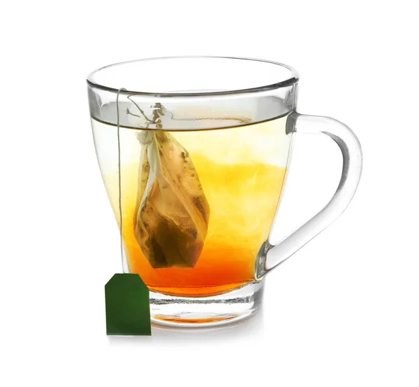 Elaboración de té caliente en taza de vidrio sobre fondo blanco — Foto de Stock