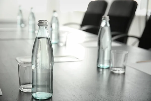 Mesa com garrafa de água preparada para reunião de negócios na sala de conferências — Fotografia de Stock