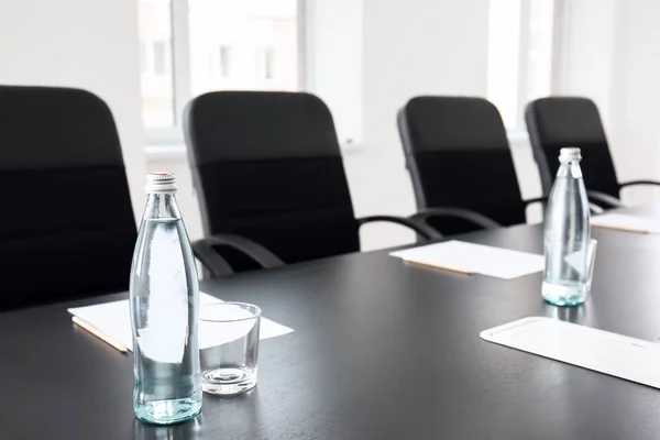 Table with bottles of water prepared for business meeting in conference hall