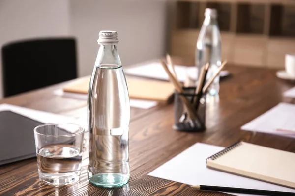 Mesa con botella de agua preparada para la reunión de negocios en la sala de conferencias — Foto de Stock