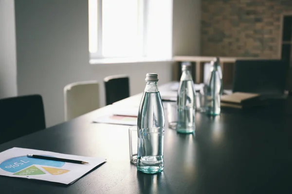 Mesa com garrafas de água preparadas para reunião de negócios na sala de conferências — Fotografia de Stock