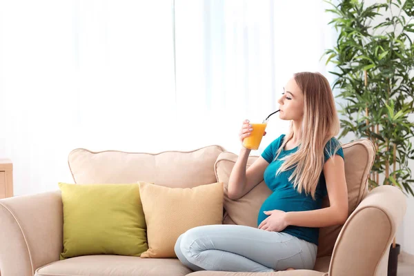 Beautiful pregnant woman drinking citrus juice at home — Stock Photo, Image