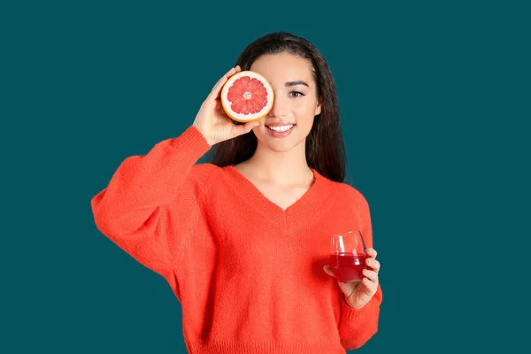 Mulher bonita com vidro de suco cítrico e frutas no fundo de cor — Fotografia de Stock