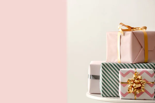 Elegantes cajas de regalo en la mesa contra el fondo de color —  Fotos de Stock